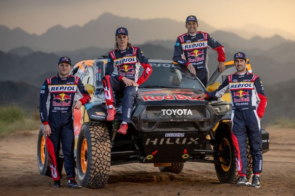 Das Team der Rallye Dakar TGR 2025 lehnt um das bunt beklebte Rallye Auto