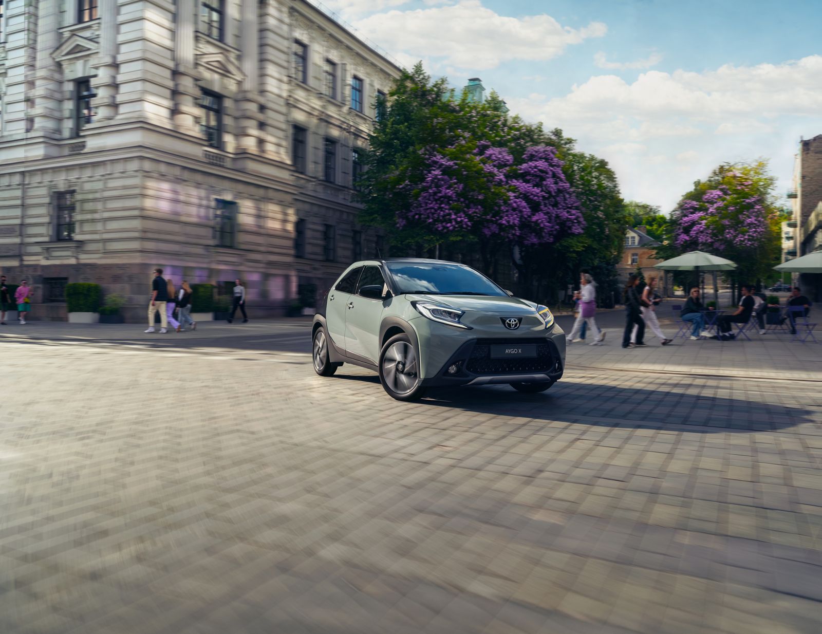 Aygo X prend les virages avec agilité sur une place de ville ensoleillée