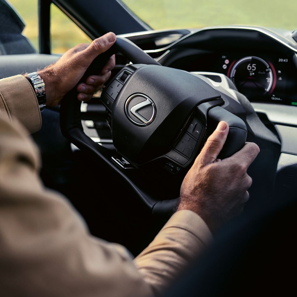 En Lexus RZ-fører med hænderne på steer-by-wire-rattet