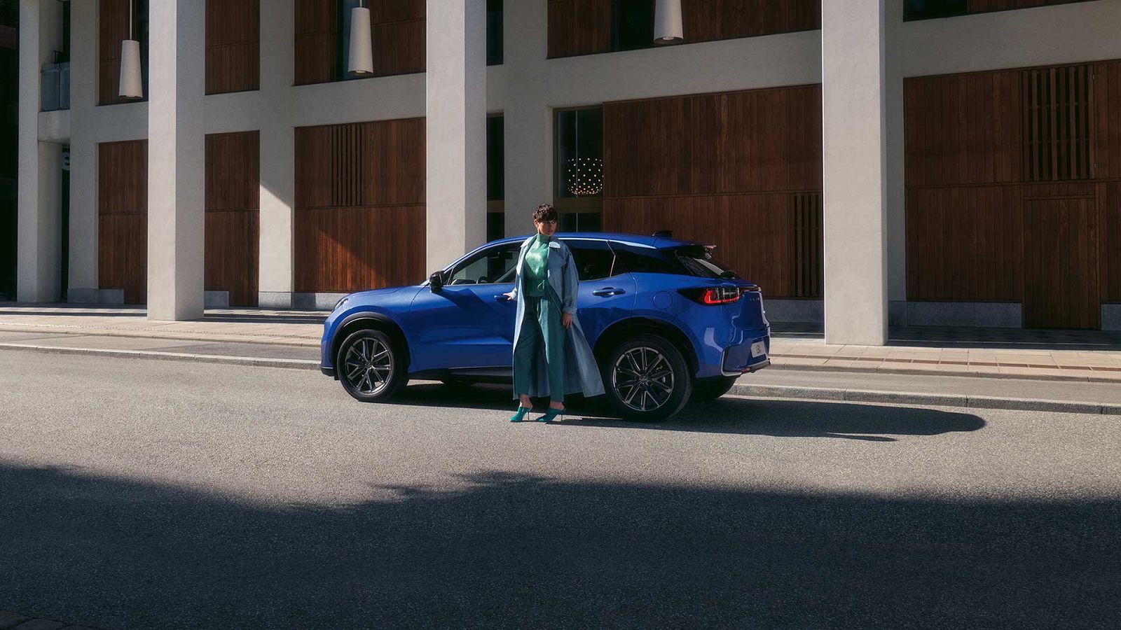 A person stood next to a Lexus LBX