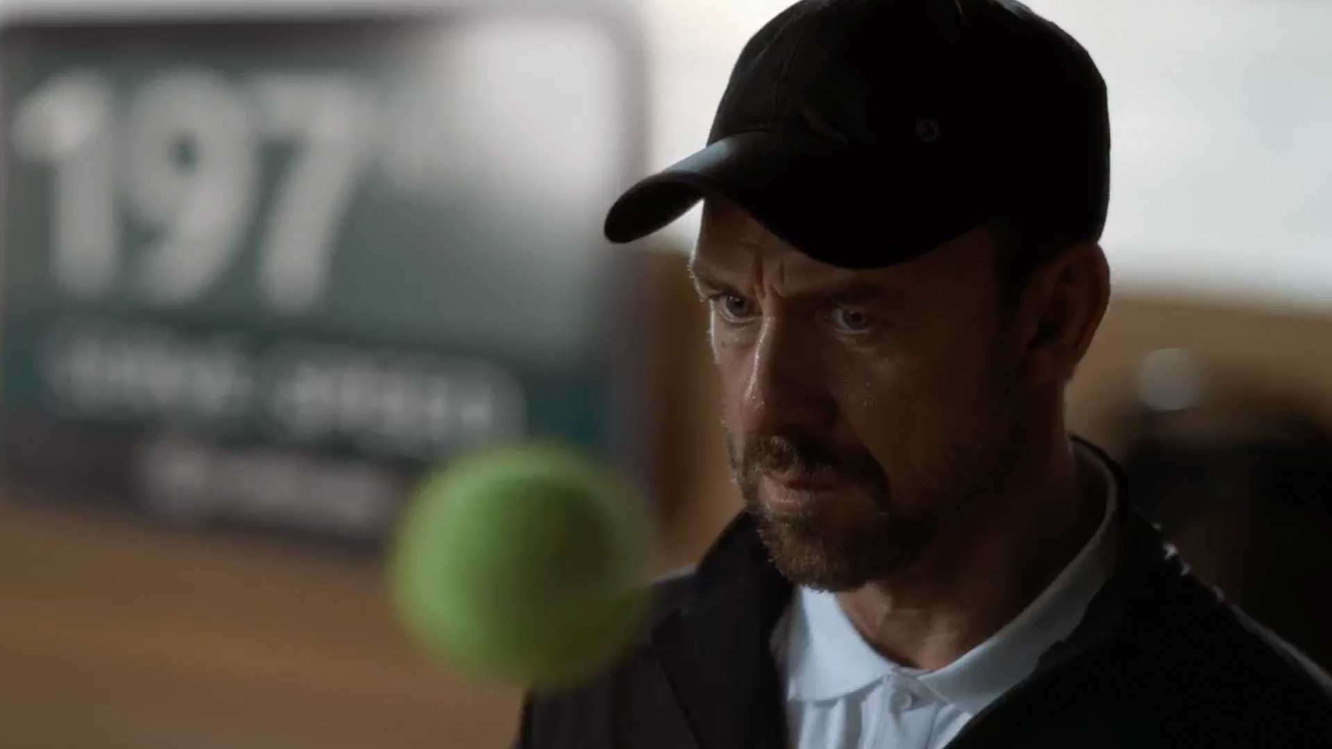 A close up of a coach and a tennis ball.