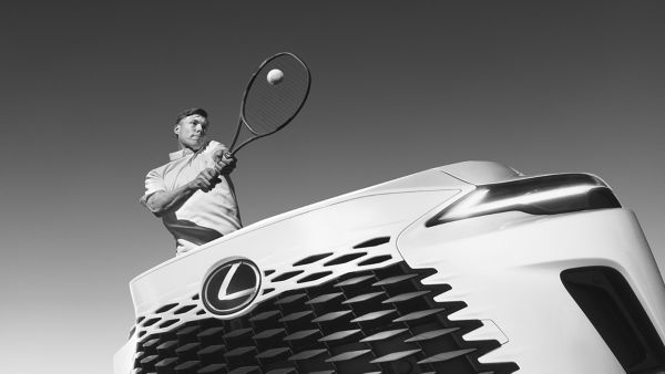 Harri Heliövaara hitting a tennis ball next to a Lexus RX