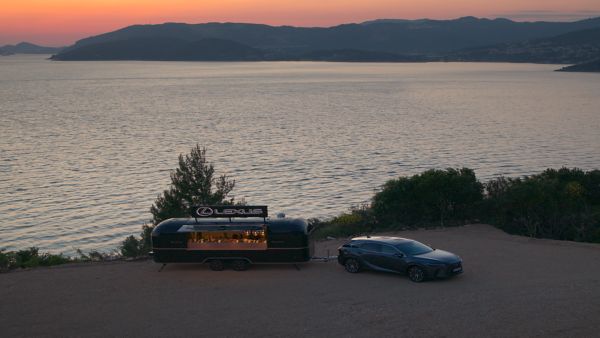 A Lexus food truck parked near sone water