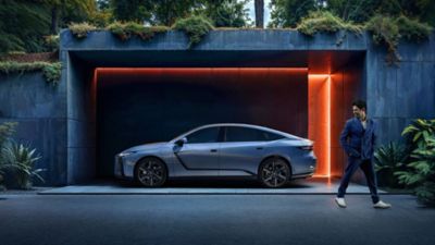 Eine Person steht draußen neben einem geparkten Lexus.