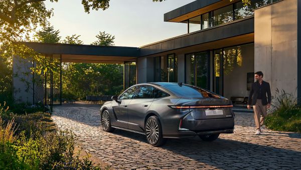 A person walking past a parked Lexus ES