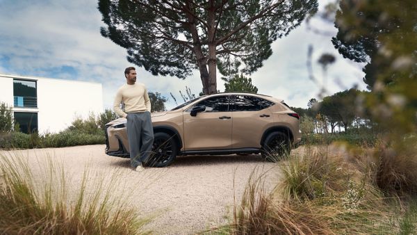 A person stood next to a parked Lexus NX