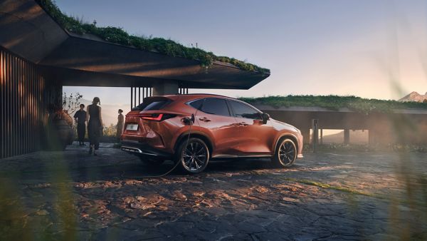 Divi cilvēki stāv pie novietota Lexus NX