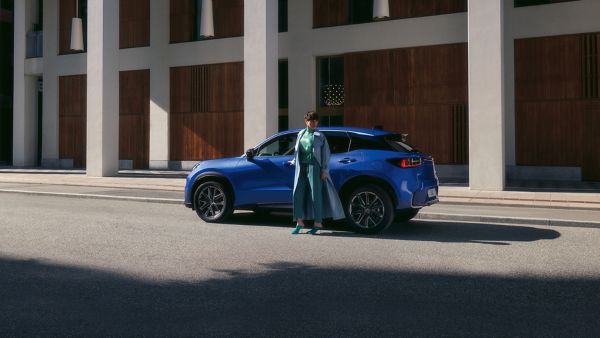 A person stood next to a blue Lexus LBX