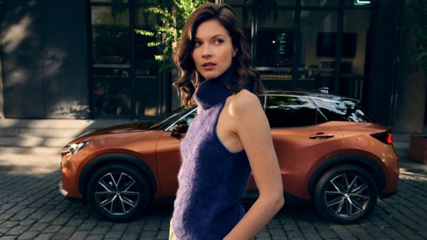 woman standing in front of a Lexus LBX