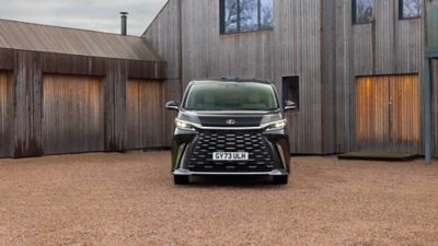 Vista frontale di Lexus LM parcheggiato all'esterno di una proprietà rivestita in legno