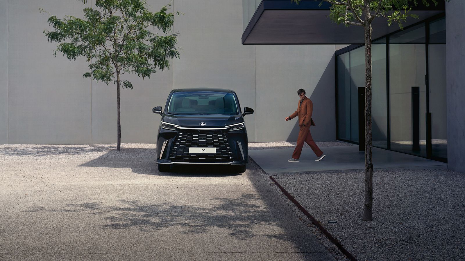 Person walking towards a parked Lexus LM