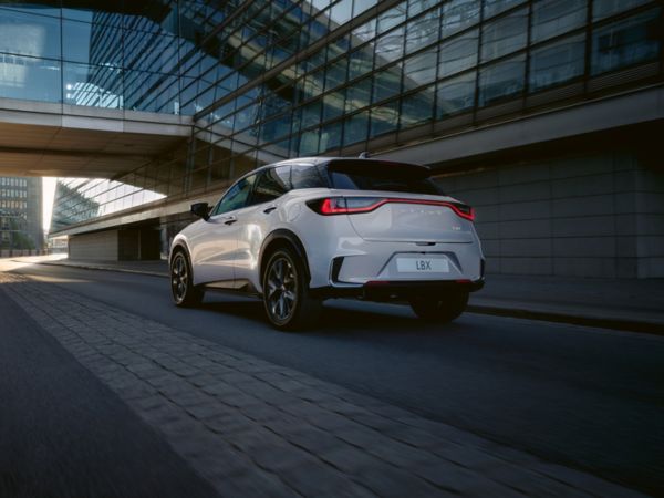 Lexus LBX Relax driving alongside a building