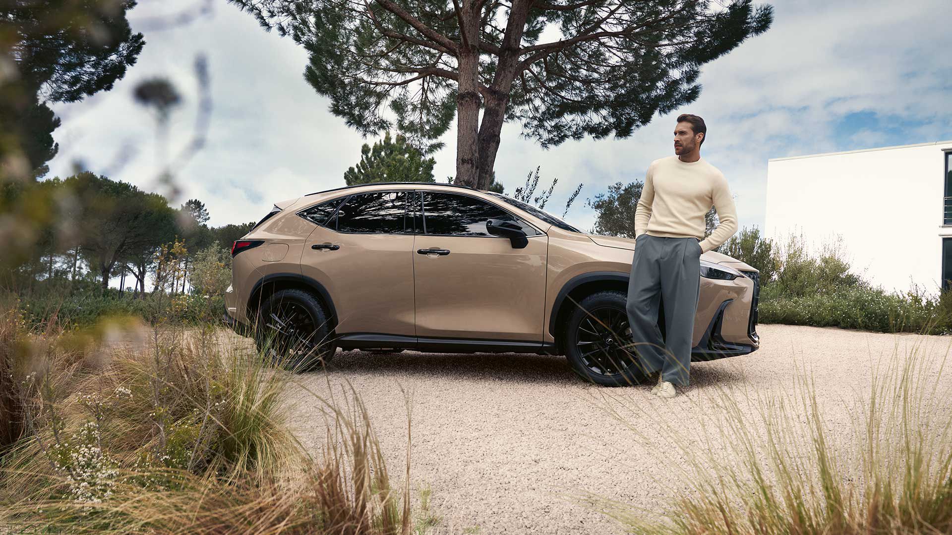 Uma pessoa encostada a um Lexus NX estacionado
