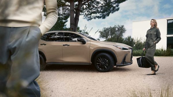 Two people stood by a parked Lexus NX