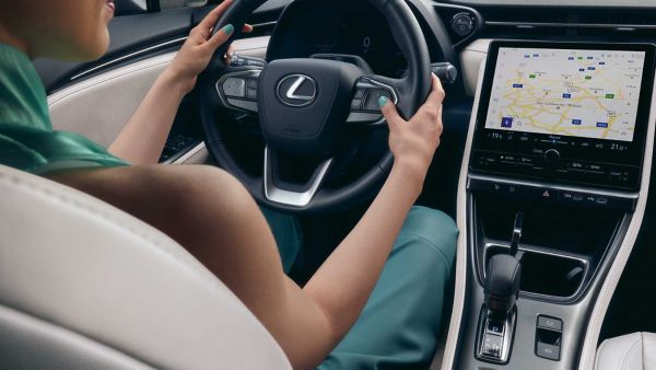 A person interacting with a Lexus multimedia touchscreen