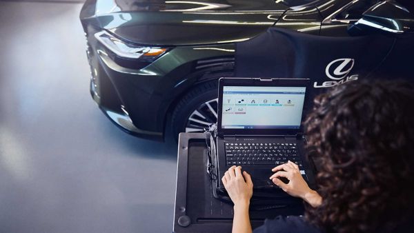 Un meccanico Lexus utilizza un computer portatile per eseguire una diagnostica