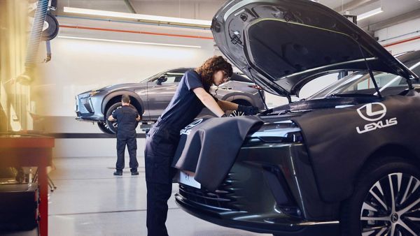 A Lexus mechanic working under the bonnet of a Lexus RX