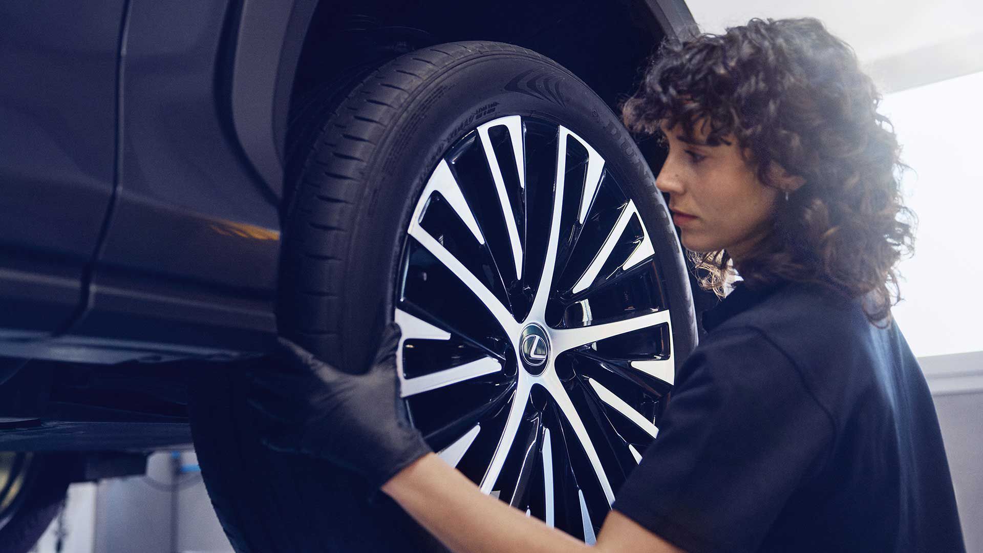 A Lexus mechanic checking a tyre
