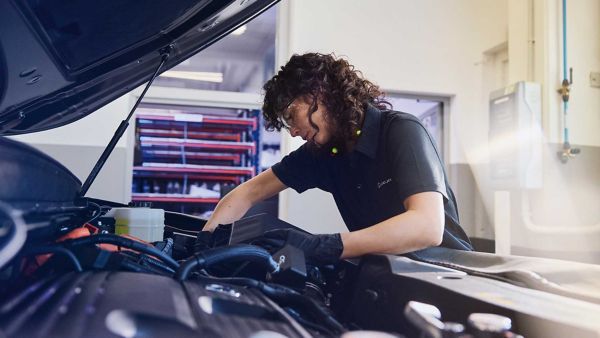 A Lexus mechanic working under the bonnet of a car