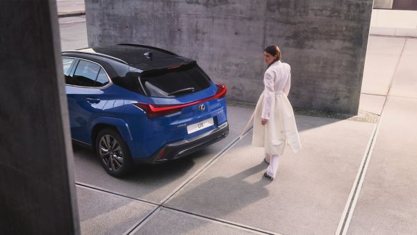 Osoba przechodząca obok zaparkowanego Lexusa UX