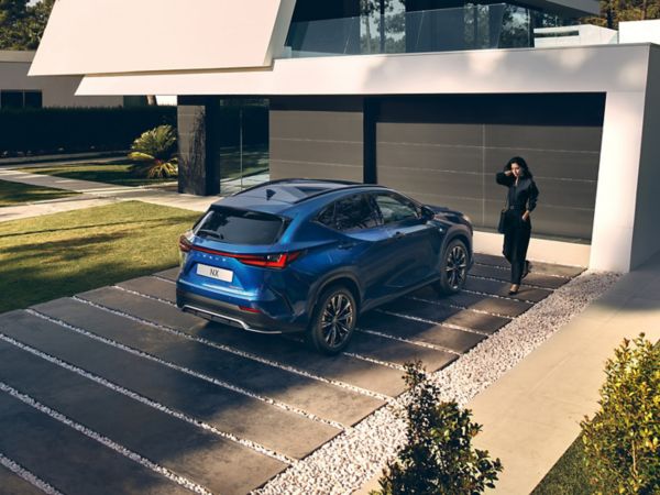 A person stood next to a blue Lexus NX