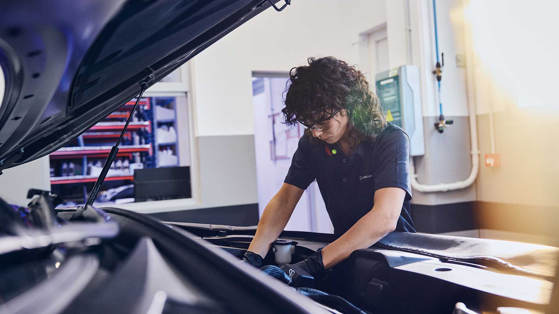 A Lexus mechanic working under the bonnet of a car