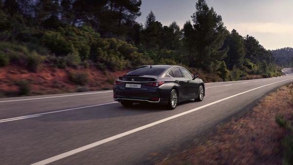 A Lexus ES 300h driving in a rural area 