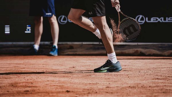 A person playing tennis on a clay court