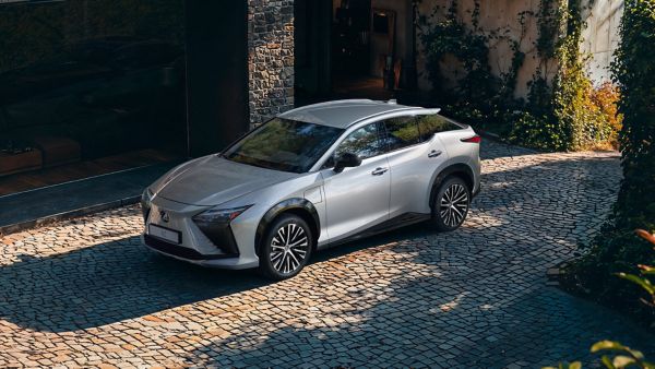 A person standing next to a Lexus ES