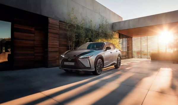 Une Lexus RZ garée devant un immeuble.