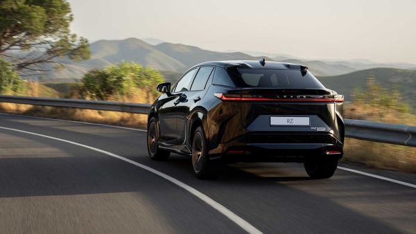 Rear view of an all-new Lexus RZ driving on a hillside road