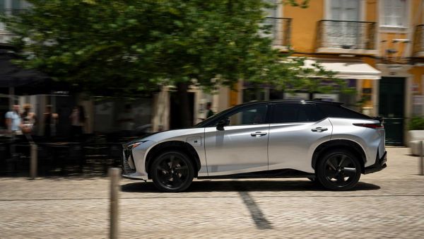 Side view of an all-new Lexus RZ F Sport driving on a road