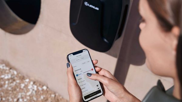 Une personne utilisant son téléphone à côté d’une Lexus