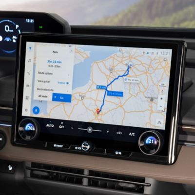 Auf dem Multimedia-System in der Mittelkonsole eines Fahrzeugs wird eine geplante Route auf einer Karte gezeigt.