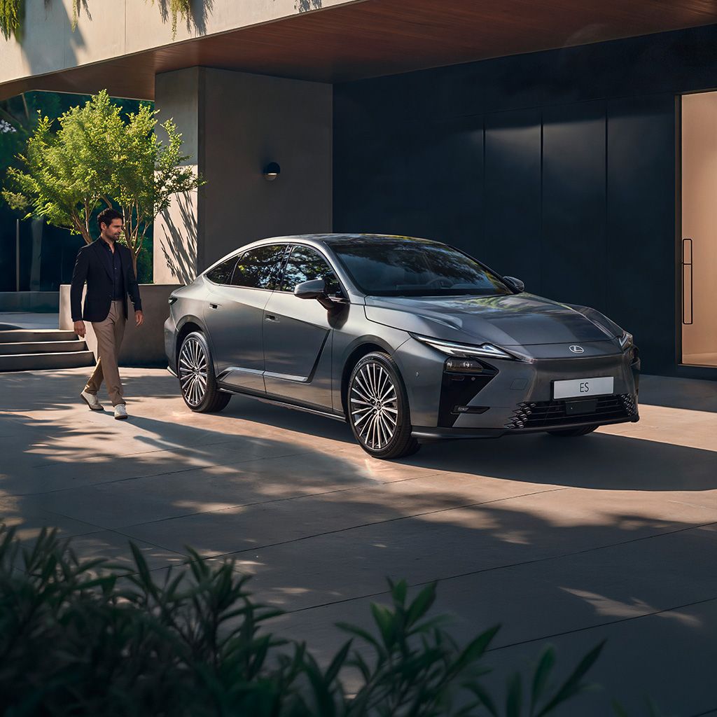 A person walking beside a parked Lexus ES