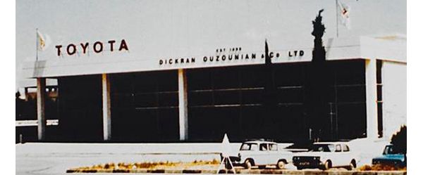 Farbfoto aus den 60er-Jahren: großes Industriegebäude mit der Aufschrift „Toyota, Dickran Ouzouninan“, davor geparkte Autos