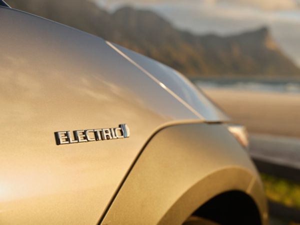 Nahaufnahme eines silbernen Elektroautos mit 'Electric'-Emblem auf der Karosserie