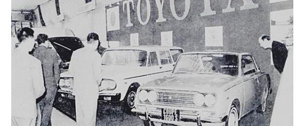Schwarz-Weiß-Foto aus den 60er-Jahren: Besucher und Fahrzeuge in einer Ausstellungshalle