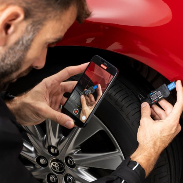 Monteur inspecteert de onderkant van een Toyota