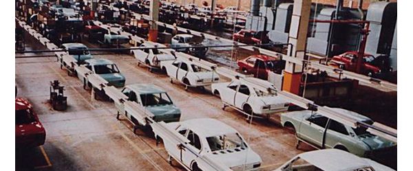 Foto von 1971: Autokarosserien stehen in mehreren parallelen Reihen von Fertigungsstraßen in einer Autofabrik 