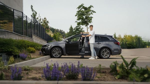 Muž stojící u svého vozu Toyota Corolla.