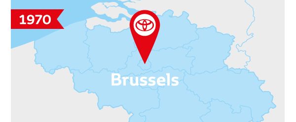 Illustration: Umrisse Belgiens in Hellblau, darauf ein mit „Brussels“ beschrifteter roter Pin mit Toyota Logo und links oben die Jahreszahl „1970“