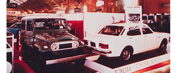 Zwei Toyota Modelle aus den 70er-Jahren, darunter ein Land Cruiser, auf Podesten in einer Ausstellungshalle