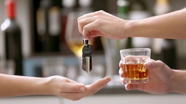 Das Bild zeigt eine symbolische Situation mit Alkohol und Autoschlüssel als Hinweis auf Trunkenheit am Steuer.