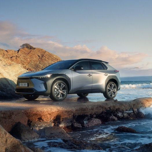 Toyota bZ4X stoi na brzegu morza.