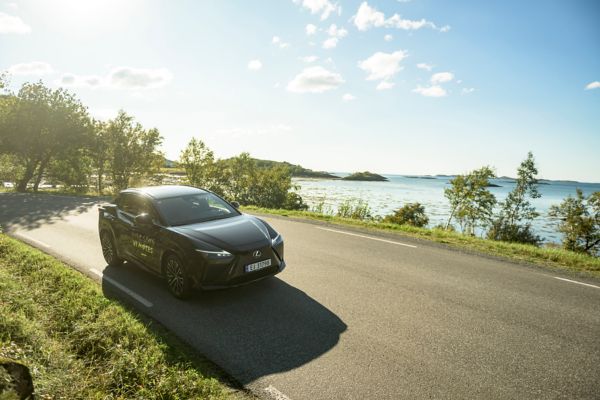 A Lexus driving along a coastal road on a sunny day