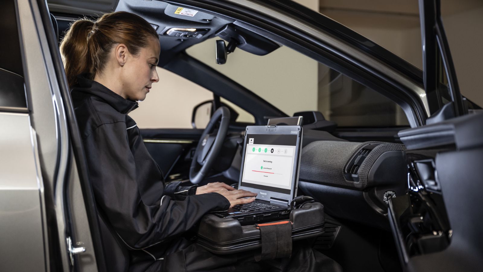 Pracowniczka serwisu Toyoty siedzi w samochodzie z komputerem.