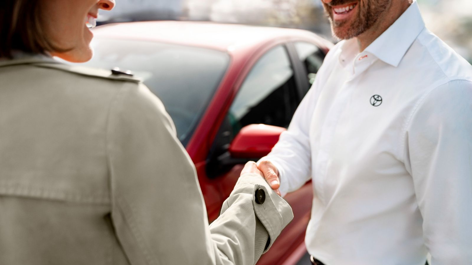 Uścisk dłoni pracownika salonu Toyoty i kobiety.
