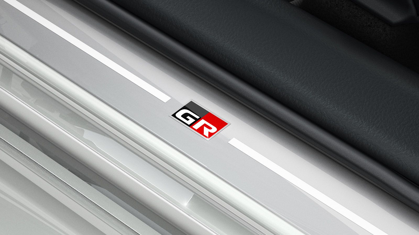 Zbliżenie logo GR SPORT na listwie progowej Toyoty.