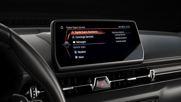 Schwarzer Innenraum eines Autos, der Touchscreen in der Mittelkonsole ist eingeschaltet und zeigt Toyota Supra Connect